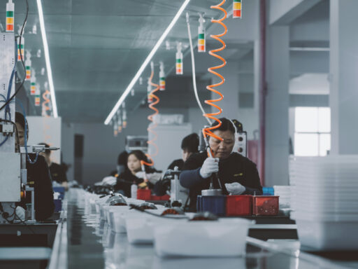 Women manufacturing electronic devices in factory.